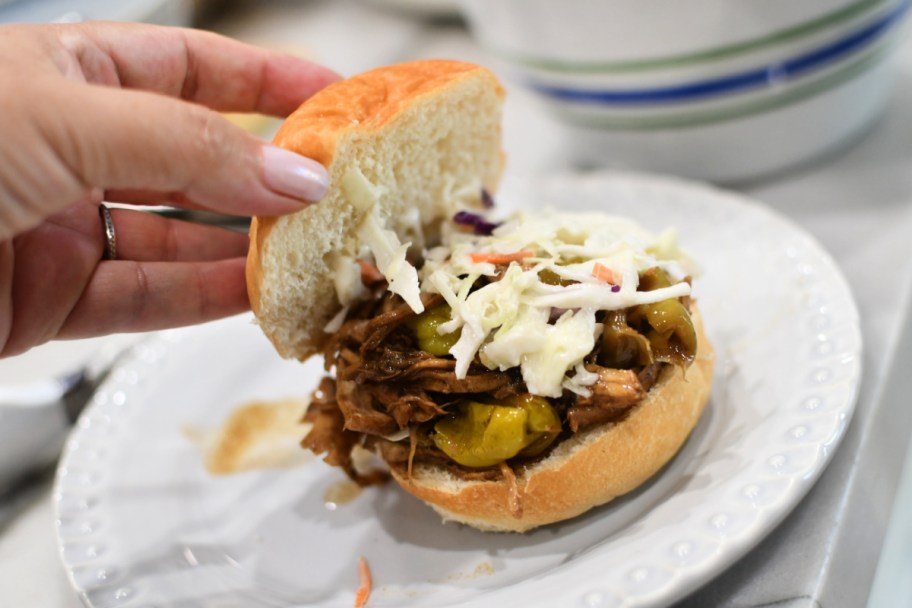 adding coleslaw to rolls with shredded chicken