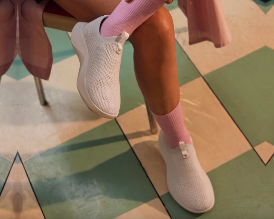 person putting on shoes on checkered floor