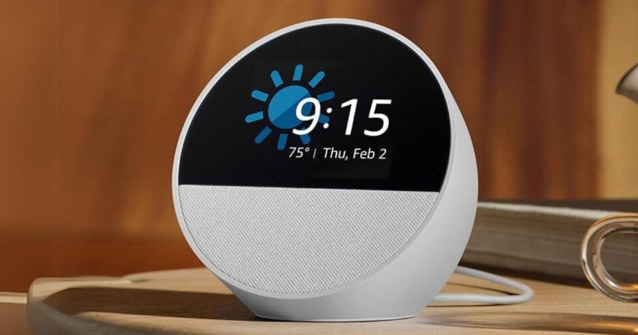 white Amazon Echo Spot device with clock on display screen that shows the time, date, and weather