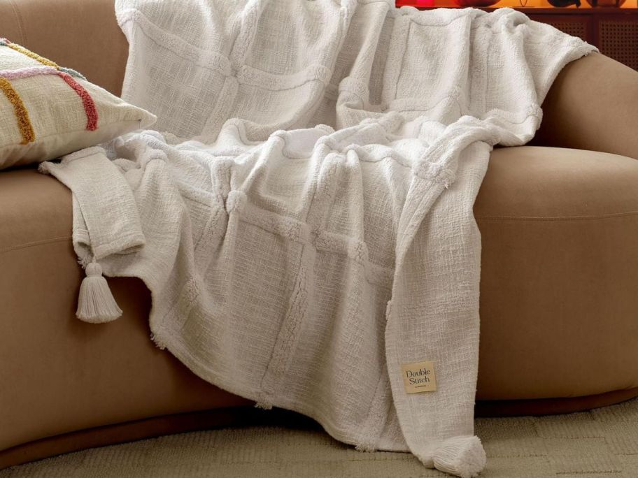 A Double Stitch by Bedsure Throw Blanket with tassels draped over a couch