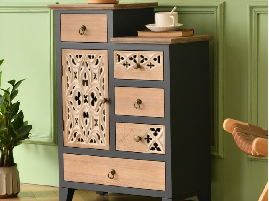 black carved side table with items on it