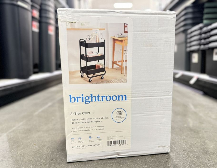 a black metal rolling cart in box on a store aisle