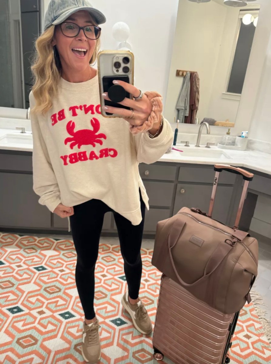 woman taking selfie in mirror wearing don't be crabby sweatshirt