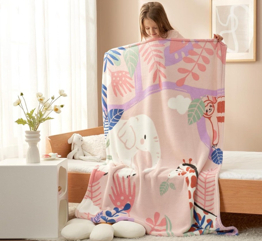 girl holding up animal blanket