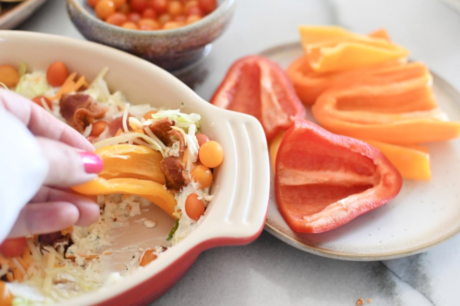 dipping a mini bell pepper in blt dip 