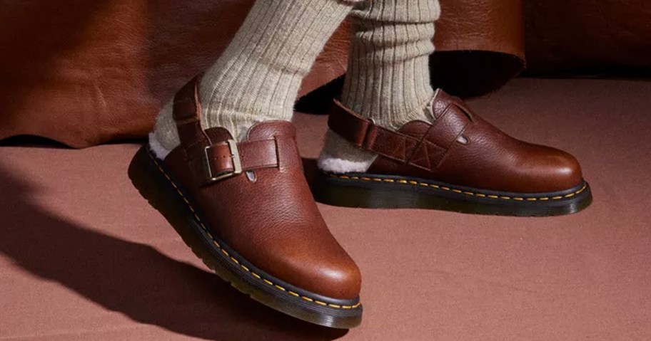 person wearing brown leather dr marten mules 
