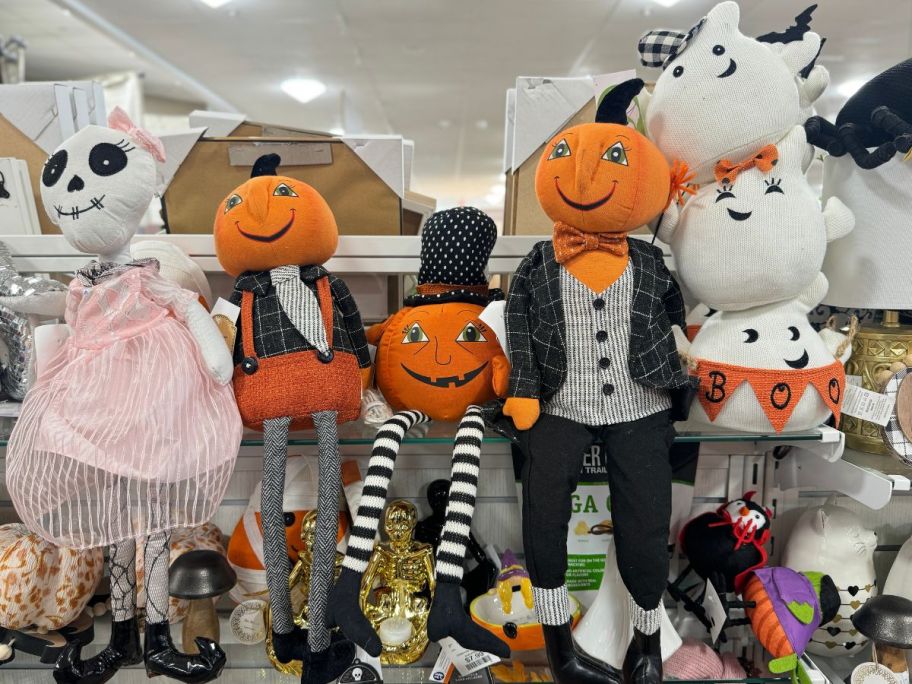 a selection of halloween themed plush dolls on store shelf