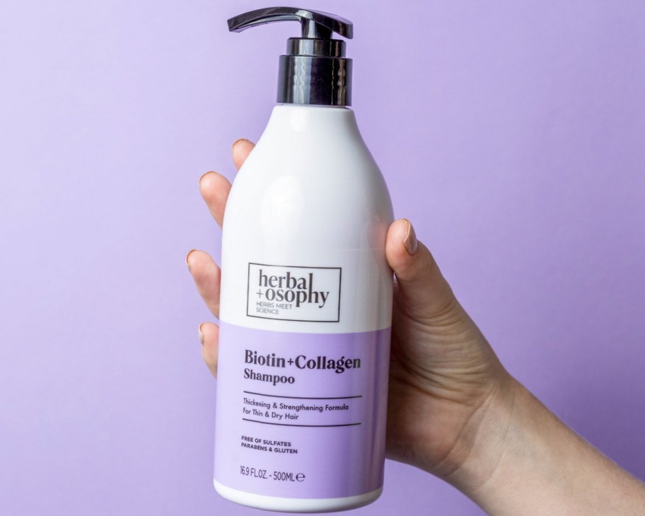 hand holding purple shampoo pump bottle