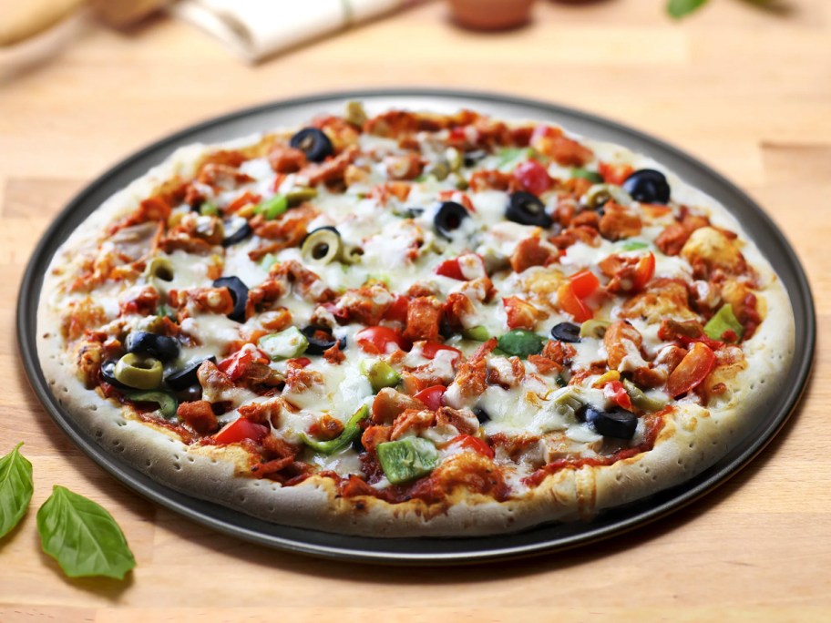 mainstays pizza pan with pizza on top on table