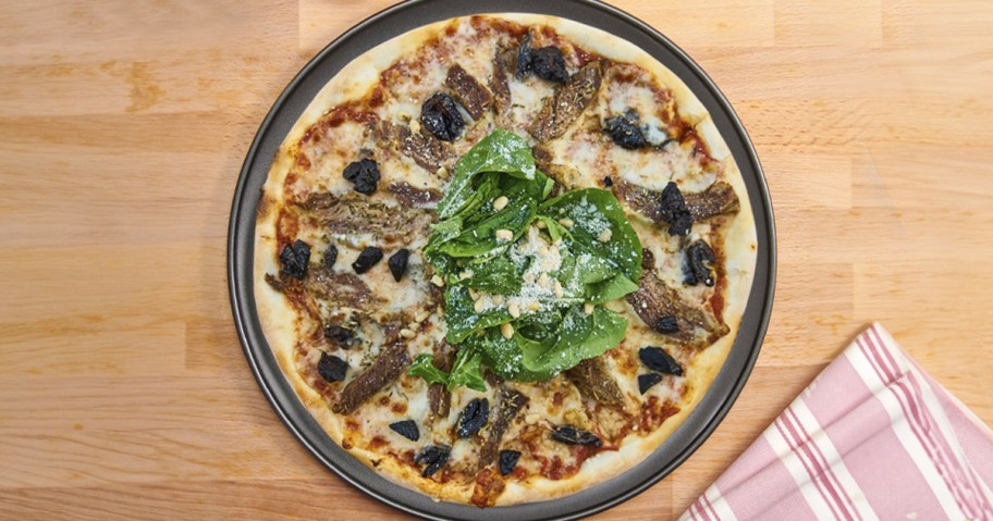 mainstays pizza pan with pizza on top on table