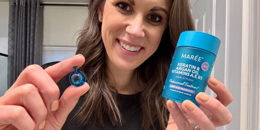 woman holding hair oil capsule and jar