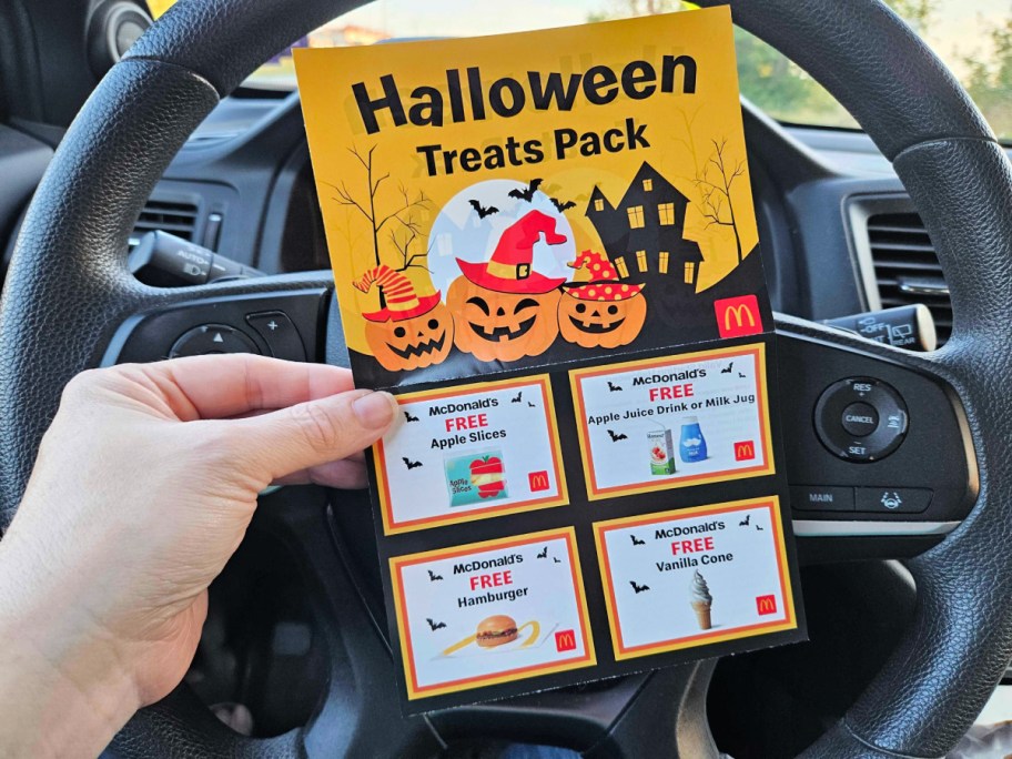 mcdonalds halloween coupon booklet being held in hand in front of a steering wheel