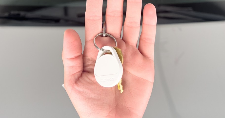 hand holding a white Momax tracker tag on a keychain