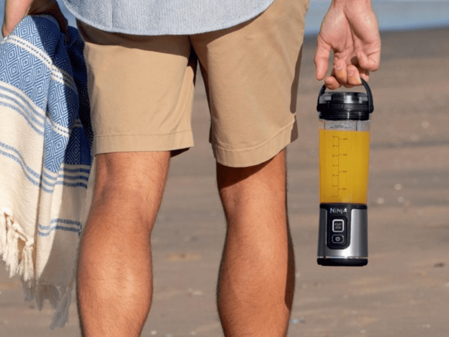 man holding ninja blast in hand on beach