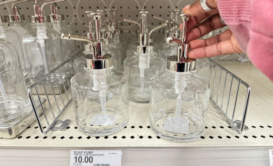 a womans hand depressing an oil can soap dispenser 