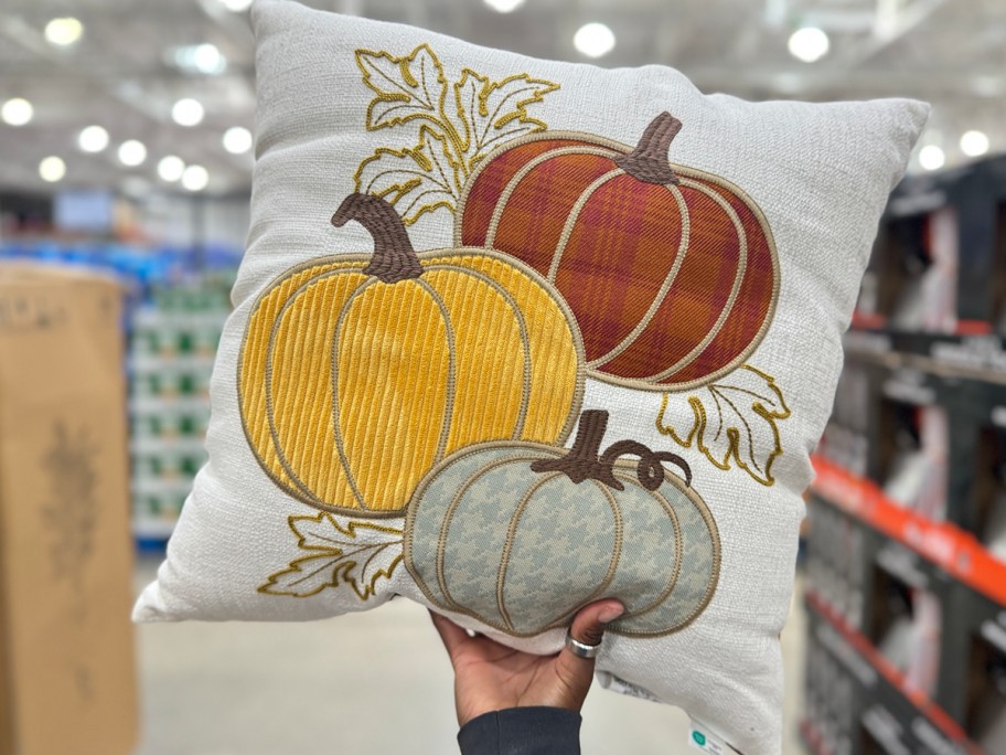 hand holding square pumpkin pillow