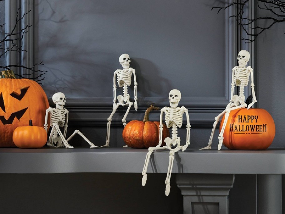 skeletons displayed on top of the table with pumpkins