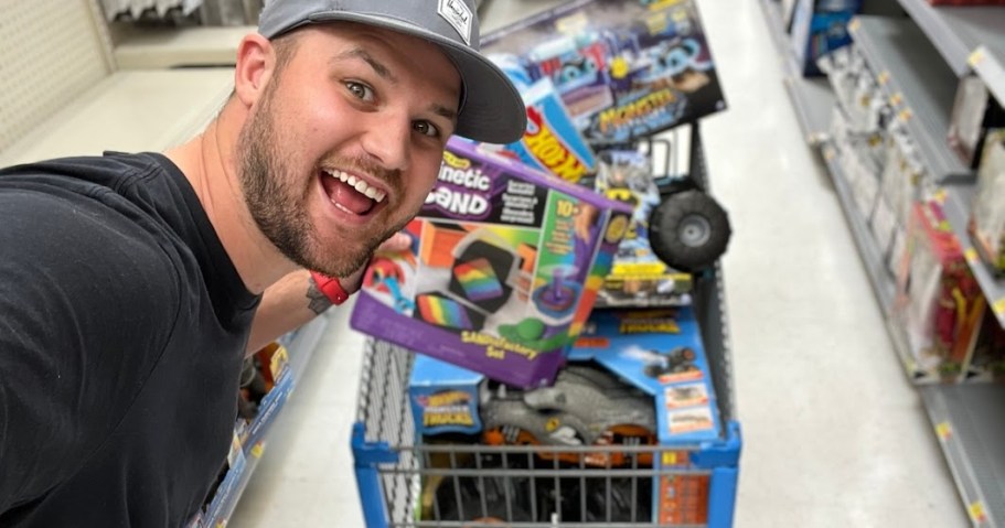 man in front of full shopping cart of toys