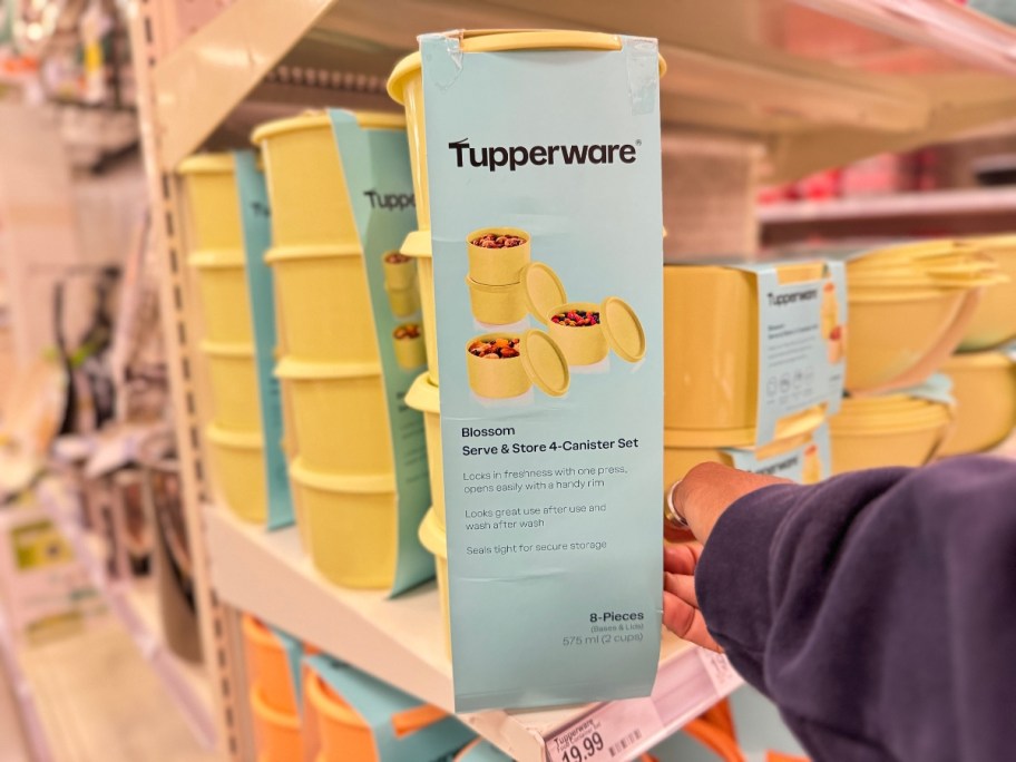 hand reaching for a set of yellow Tupperware containers on a store shelf