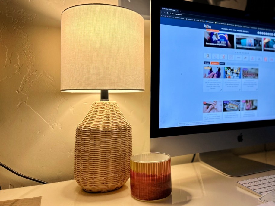 rattan lamp in dark room with light under white lamp shade on desk