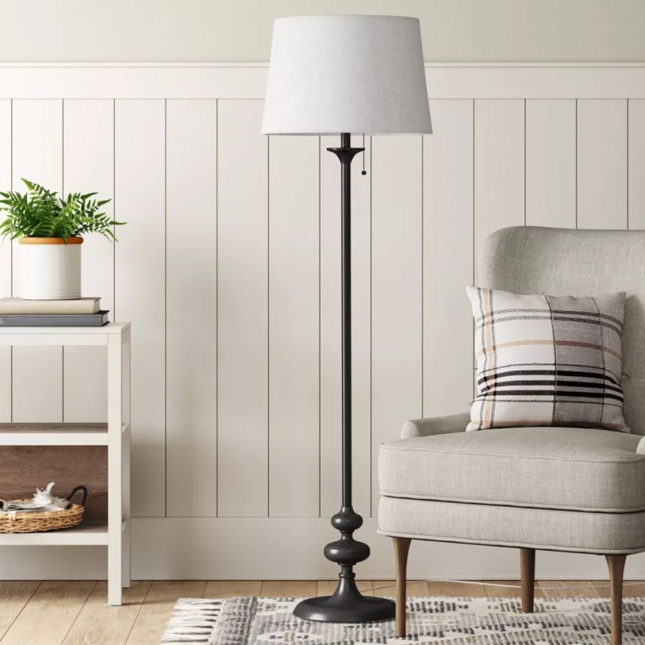 floor lamp with a decorative black base and white shade in a living room