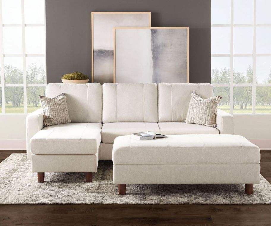 a cream colored sectional shown with storage ottoman