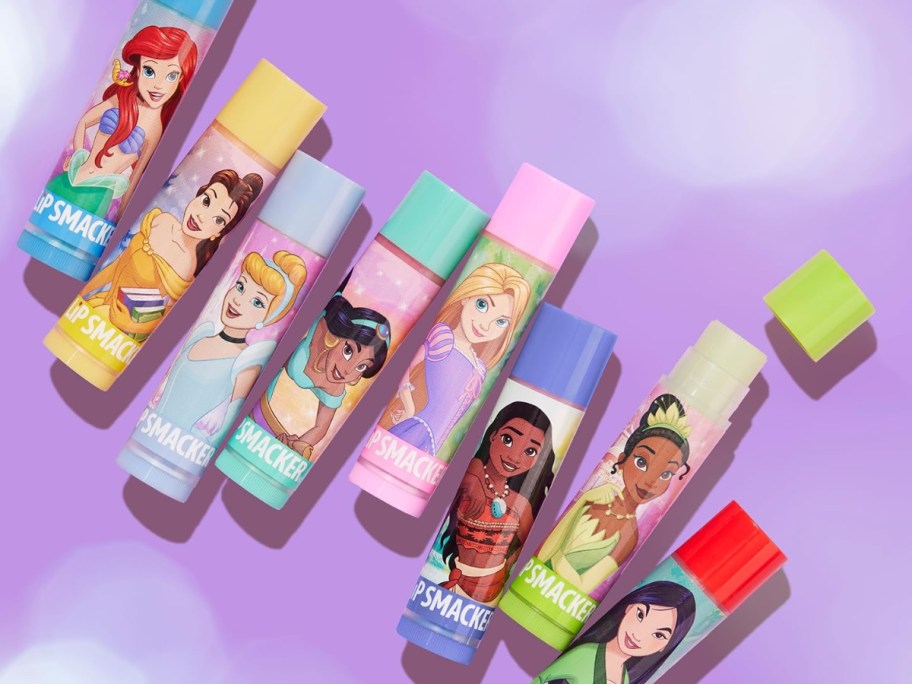 8 Disney Princess Lip Smacker Lip Balms on a purple background