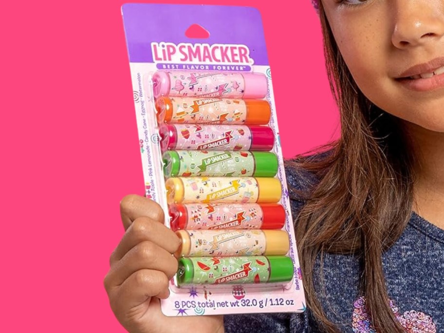 little girl holding a pack of Lip Smacker Holiday Original & Best Lip Balms