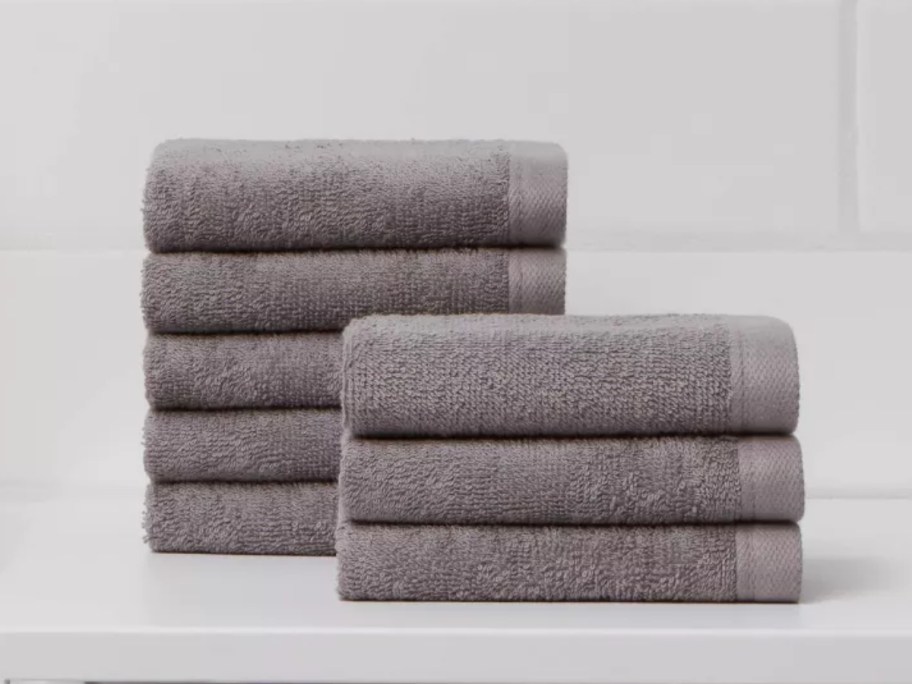 set of 8 grey washcloths in 2 stacks on a bathroom counter