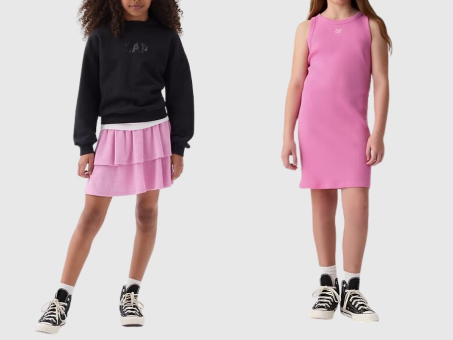 girl wearing a pink ruffle skirt and black hoodie and girl wearing a pink tank dress