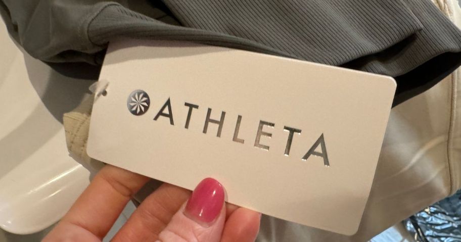 Hand holding the tag on a pair of Athleta Joggers