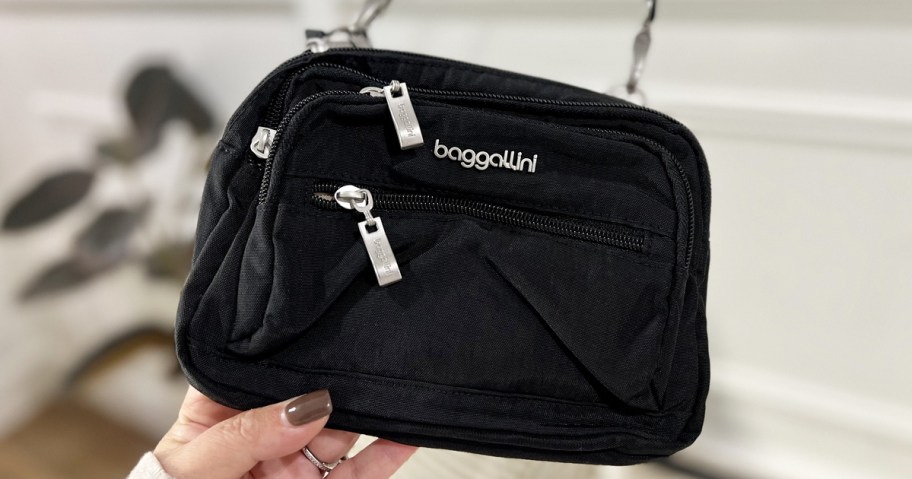 hand holding a black baggallini bag