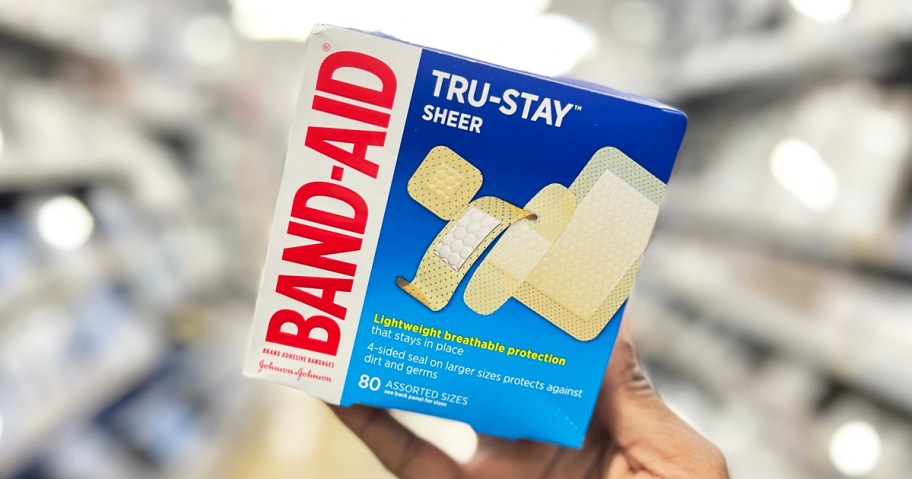 hand holding up a box of Band-Aid Tru-Stay Sheer Bandages