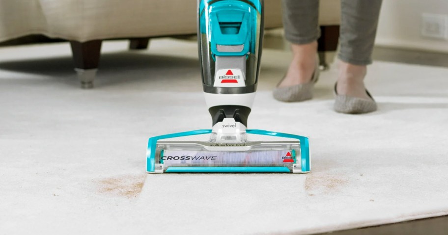 using a blue Bissell CrossWave on area rug