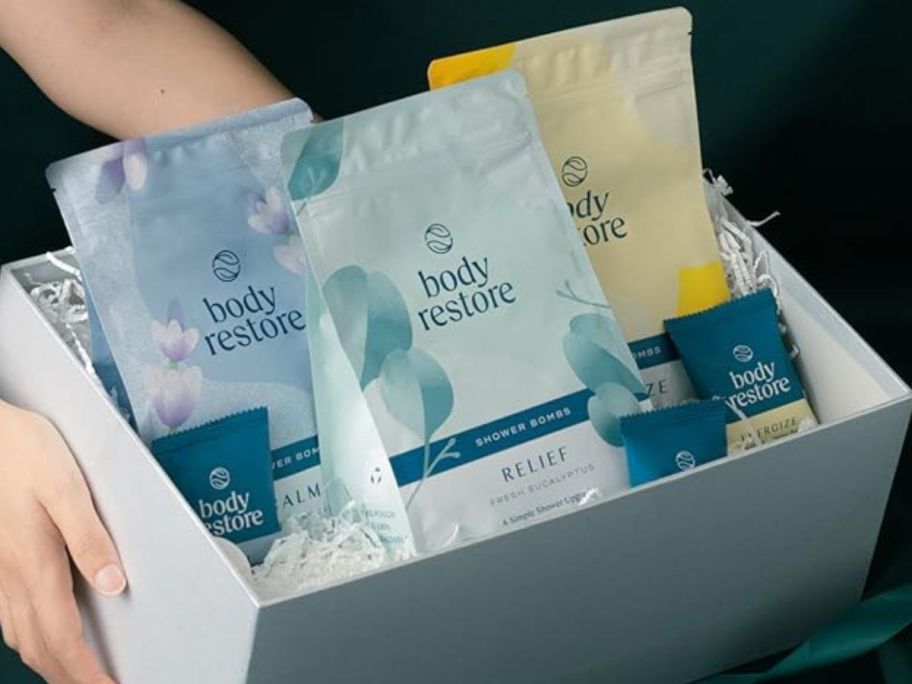 A box with three bags of Body Restore Shower Steamers in it