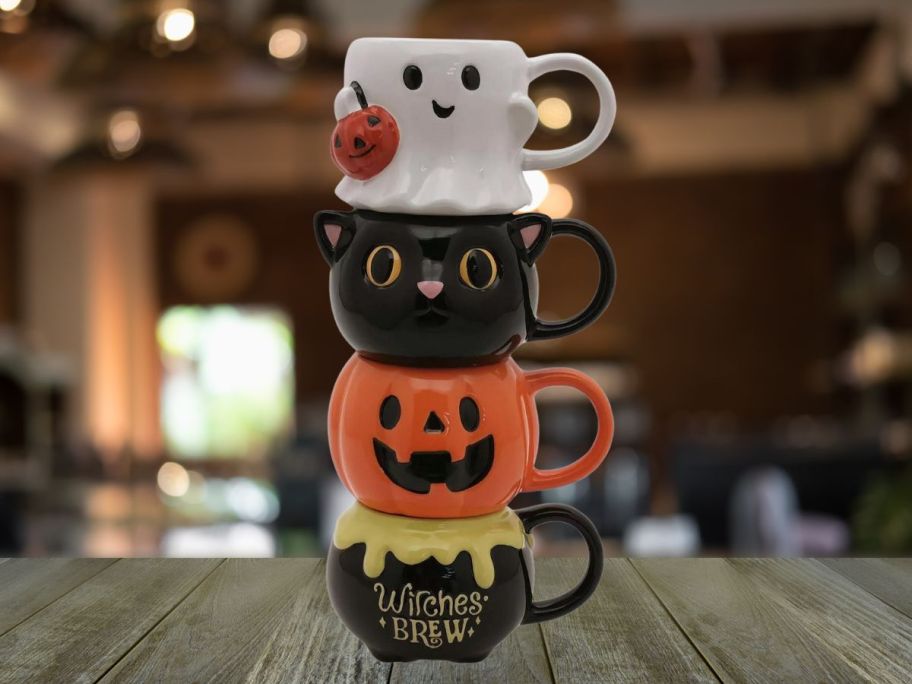 Celebrate Together Halloween Ghost, Black Cat, Jack-o-Lantern, & Cauldron Stacking Mugs on table