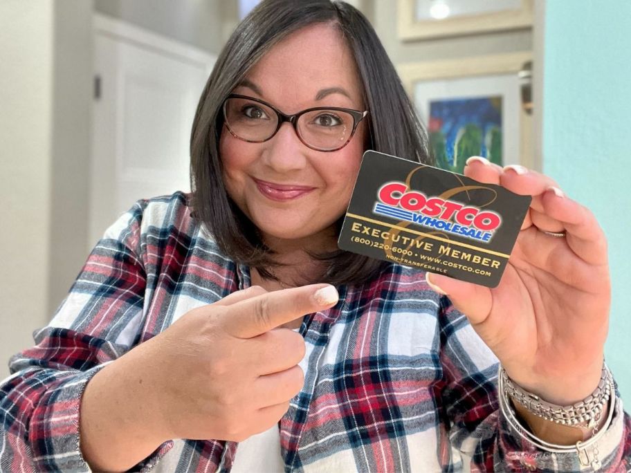 woman holding a costco executive membership card 