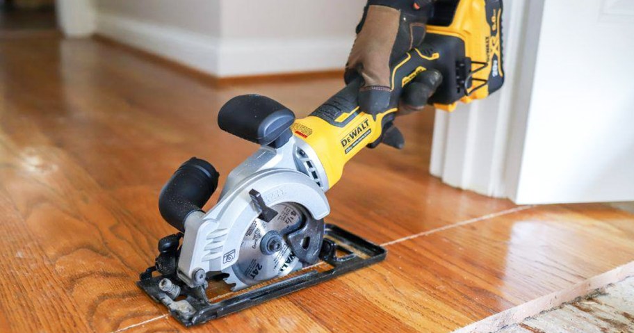 person using DEWALT Circular Saw to cut wood flooring