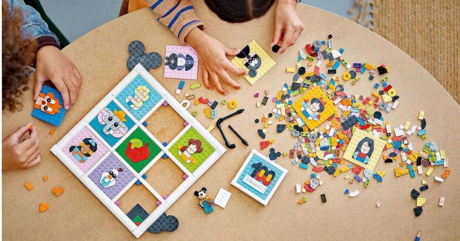 2 kids playing with a disney 100 lego set