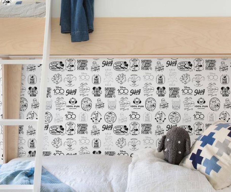 a kids bedroom wallpapered in Disney 100th wallpaper