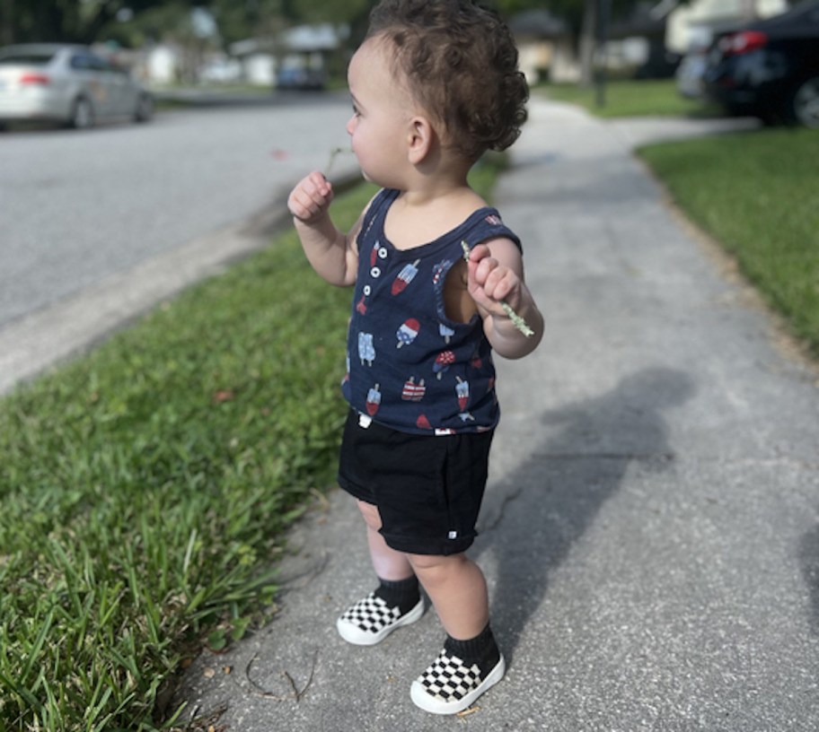 toddler boy on sidewalk looking out at street