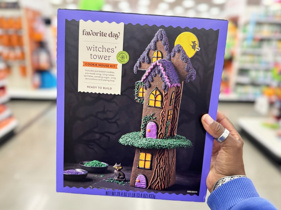 hand holding up a Halloween Witches Tower Cookie House Kit in store