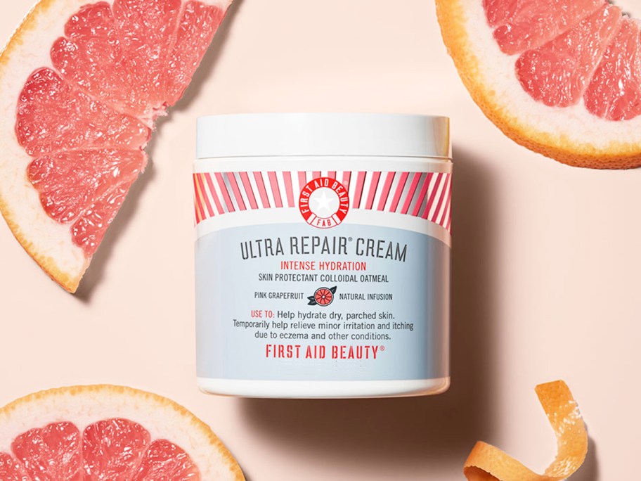 jar of First Aid Beauty Grapefruit Ultra Repair Cream near grapefruit slices