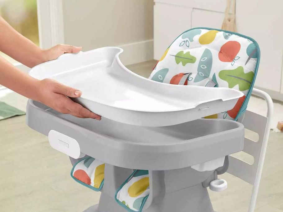 hands adjusting Fisher-Price SpaceSaver Simple Clean High Chair