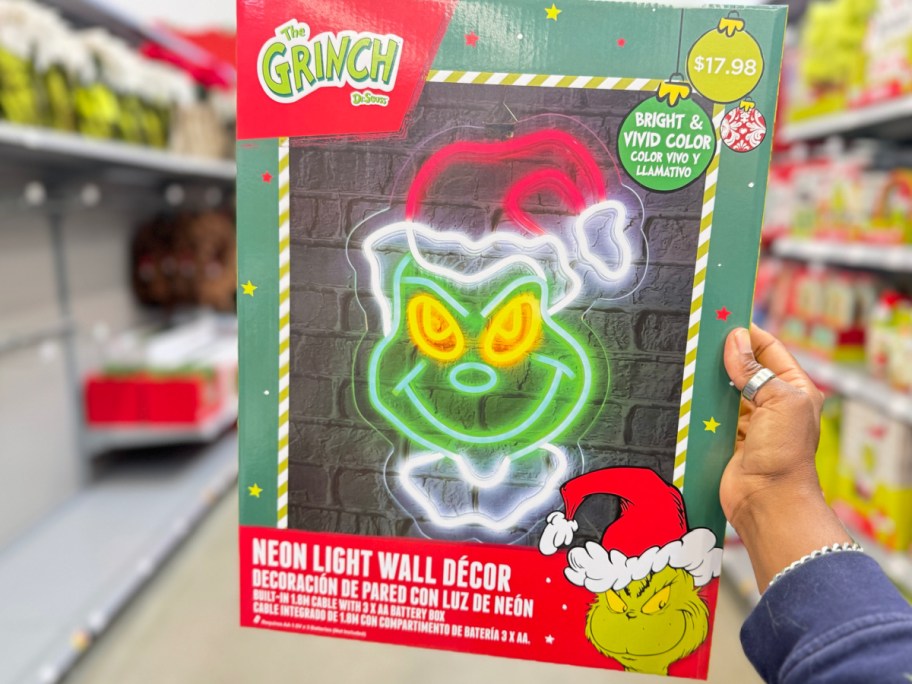 Grinch neon sign in woman hands