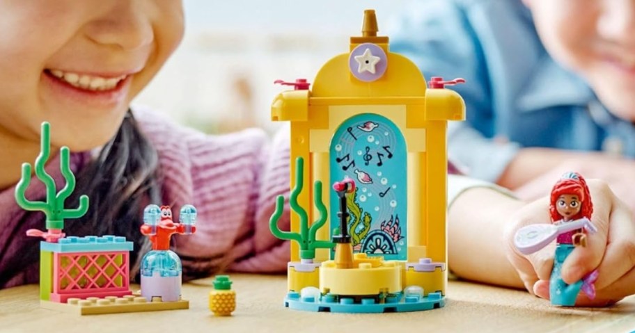 kids playing with a LEGO Disney Princess Ariel’s Music Stage set