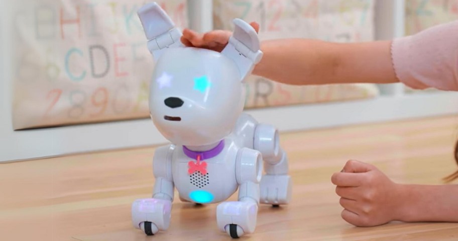 a white robot dog with a little girl's hand petting it