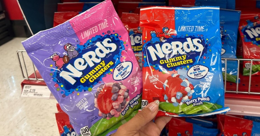 hand holding 2 bags of Nerds Gummy Clusters in Grape Strawberry Blitz and Berry Punch Rush