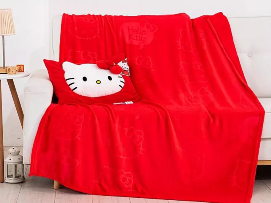 red blanket and red Hello Kitty pillow over a couch