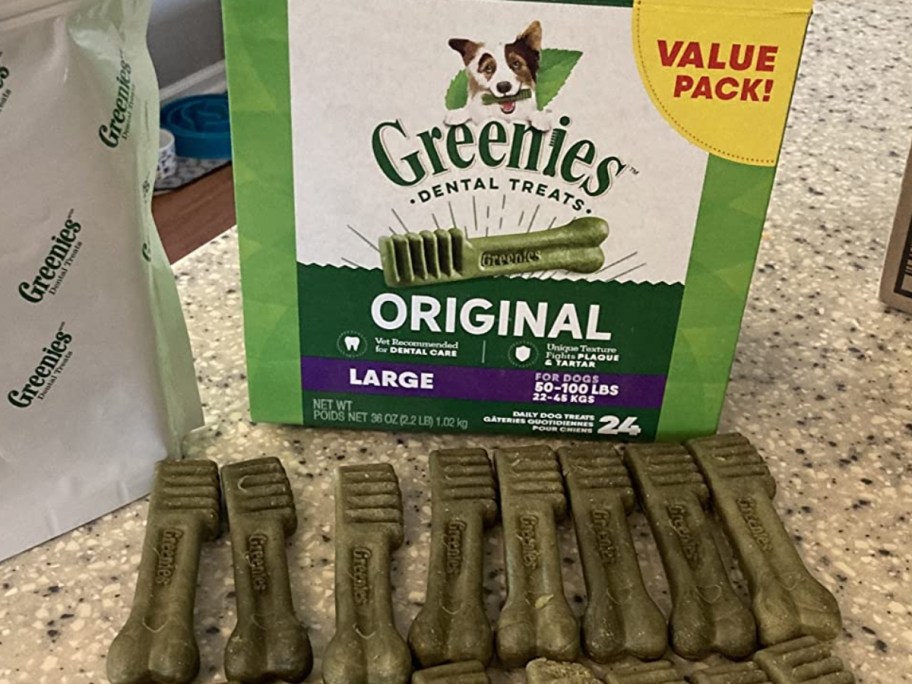 box ofGreenies Original Large Natural Dental Care Dog Treats with some laid out in front of it on a counter